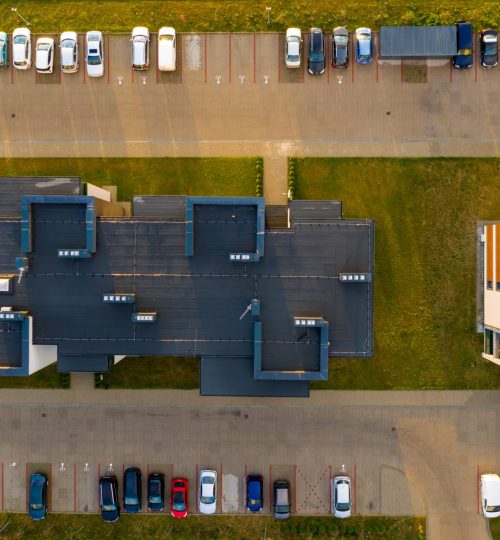 Top down view on multi-family houses and parking with cars.